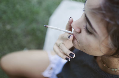 Close-up of woman smoking marijuana joint outdoors