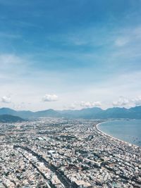 Aerial view of city against cloudy sky