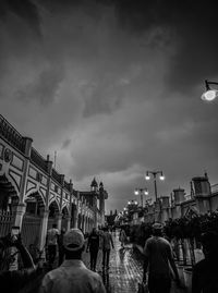 People on street in city against sky