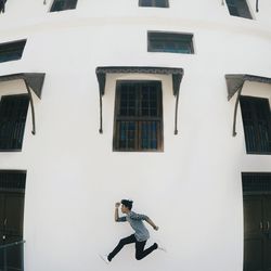 Side view of woman walking against buildings in city