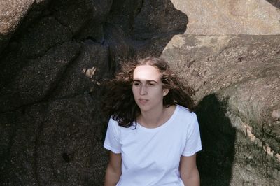 Young woman sitting on rock at beach