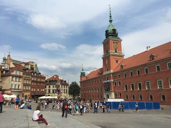 People in city against cloudy sky