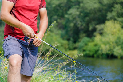 Midsection of man holding plants in river