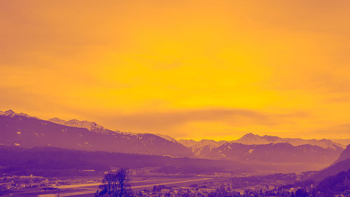 Scenic view of snowcapped mountains against romantic sky at sunset