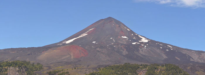 View of volcanic mountain against blue sky