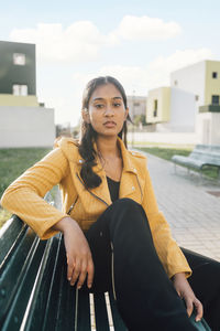 Young woman with blank expression sitting on bench