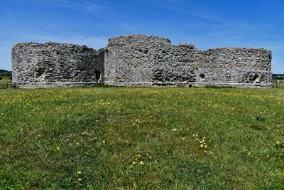 Stone wall on field against clear sky