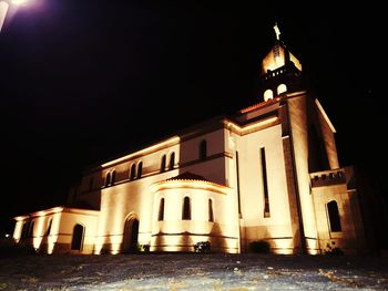 Illuminated building against sky at night