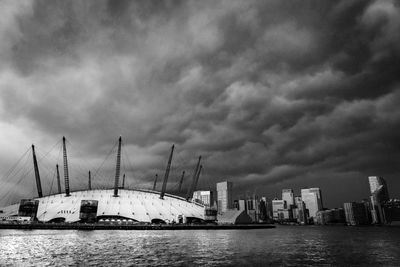 Sailboats in sea by modern buildings against sky