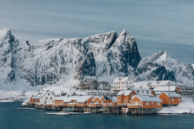 Buildings by sea against sky during winter