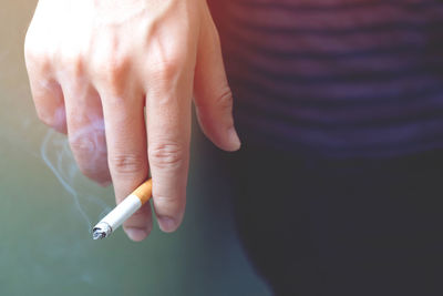 Close-up of hand holding cigarette