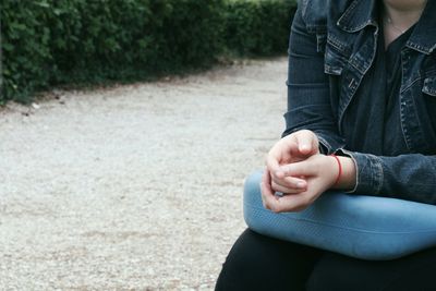 Low section of woman sitting outdoors