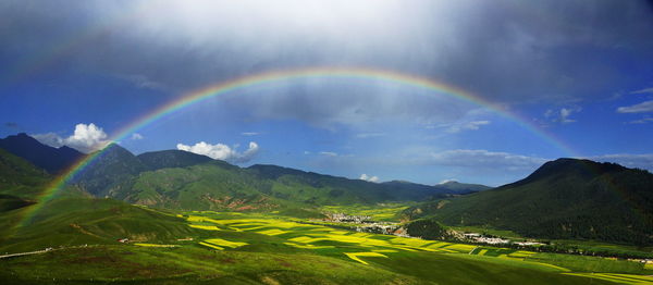 Scenic view of rainbow over mountains against sky