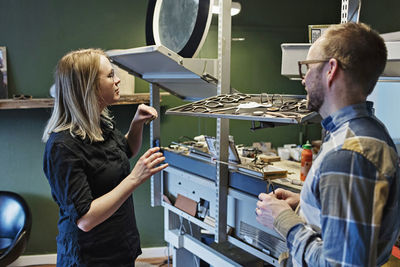 Side view of owners working at eyeglasses workshop