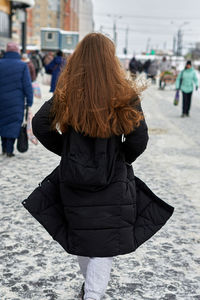 Rear view of woman walking on street in city