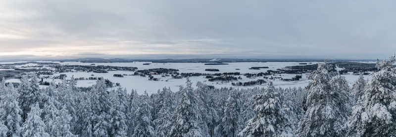 Panoramic view of snow covered land against sky