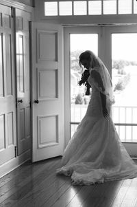 Bride standing against wooden door