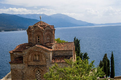 Houses by sea against sky