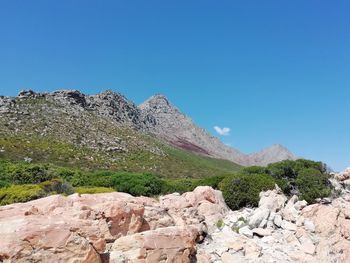 Rocks on mountain against clear blue sky