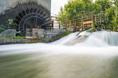 View of waterfall with bridge in background