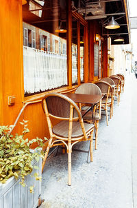 Close-up of empty tables and chairs at sidewalk cafe