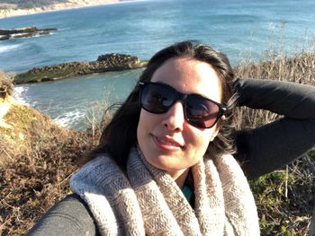 Portrait of woman wearing sunglasses against sea