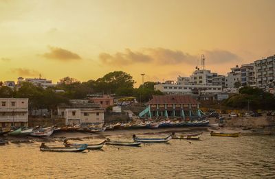 Boats moored at harbor against sky