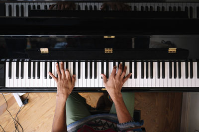 Young male musician playing piano at home
