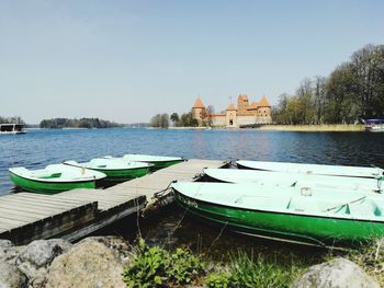 Boats moored in lake against clear sky