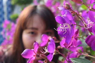 Close-up portrait of woman by flowering plant