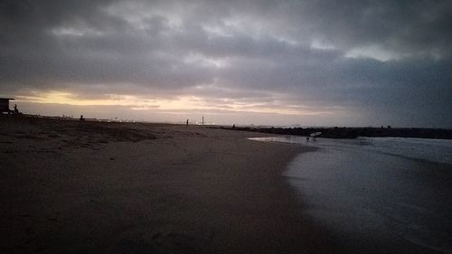 View of beach against cloudy sky