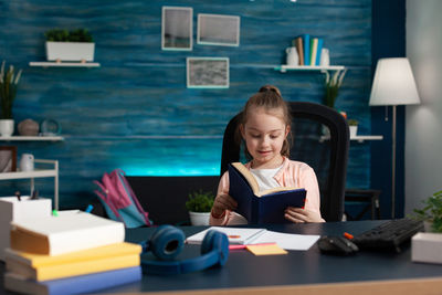 Full length of girl sitting on table