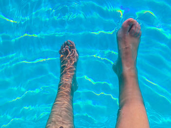 Low section of person swimming in pool