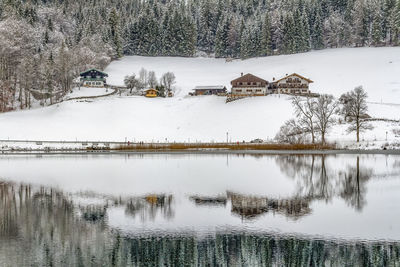 Scenic view of lake by building during winter