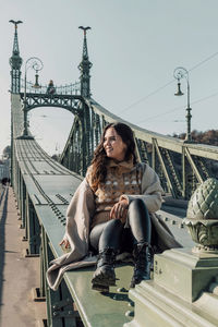 Lifestyle photo of attractive woman sitting on liberty bridge in budapest, hungary