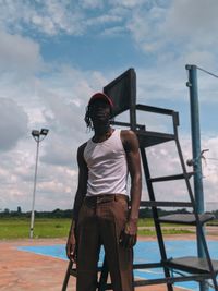 Portrait of young man standing against sky