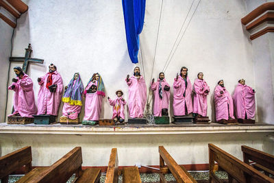 Rear view of people standing against pink wall