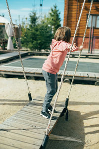 Full length of boy on swing in playground