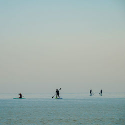 People in sea against sky