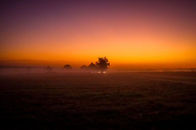 Scenic view of field against clear sky during sunset