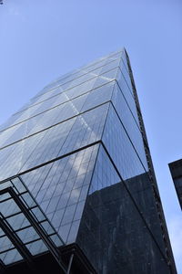 Low angle view of glass building against clear sky