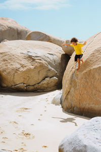 Boy jumping off rocks