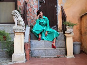 Woman sitting on the stairs of her house