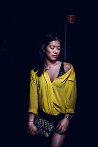 Beautiful young woman against black background