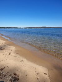 Scenic view of beach against clear blue sky