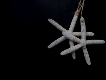 Close-up of cross on table against black background