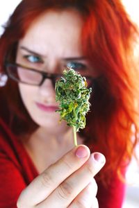 Close-up portrait of woman holding red flower