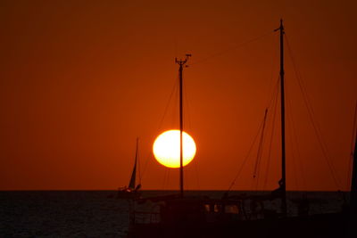 Silhouette of boat in sea during sunset