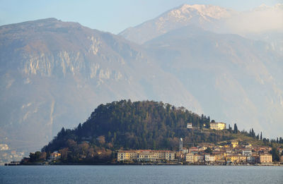 Scenic view of lake como by village against mountains