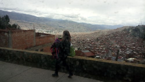 People looking at cityscape against sky